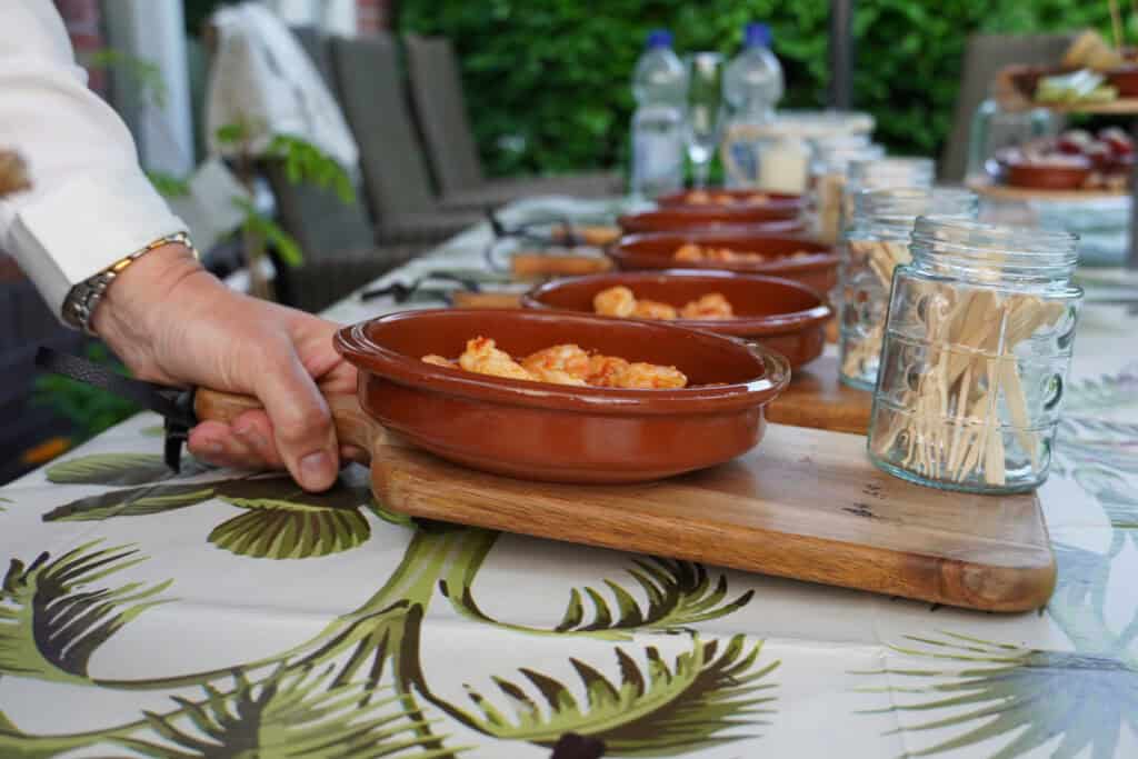 Gambas al Ajillo: gamba’s gebakken in knoflookolie en chili, warm geserveerd met fijne garnituur.